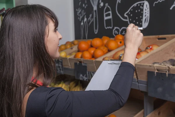 Vrouwelijke stagiair telt vruchten terwijl de inventaris — Stockfoto