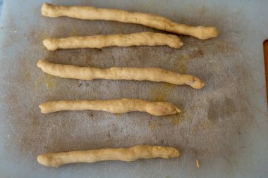 struffoli 1 'i hazırlayın. Yumurta, un, Marsala şarabı ve şekerden yapılan hamuru bir sopa şeklinde yuvarla ve parçalara böl.