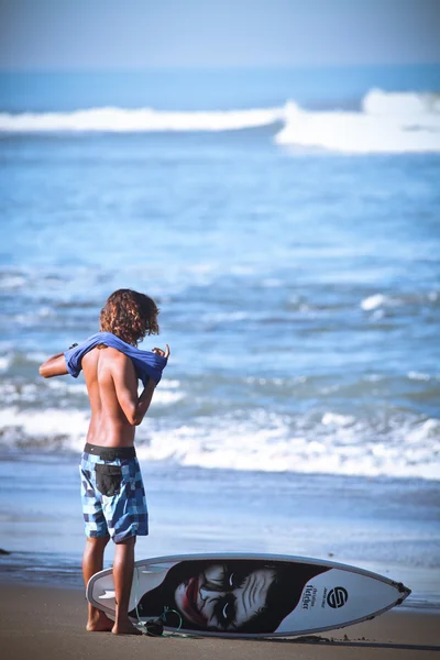 Il surfista con un'asse su una spiaggia — Foto Stock