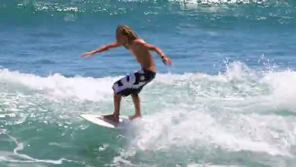 Серфер с доской на волнах — стоковое видео