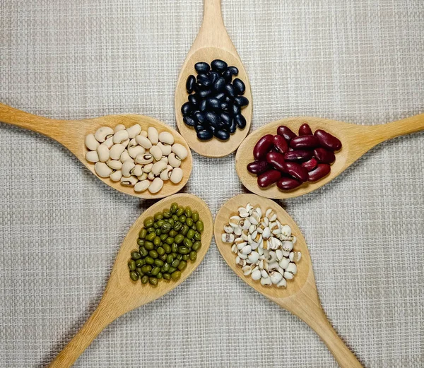 青い豆 赤い豆 黒い豆 白い背景に隔離された木製のスプーンで黒い目のエンドウ豆とキビ — ストック写真