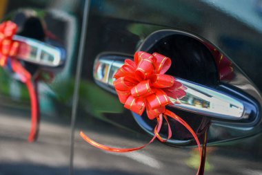 Kırmızı kurdele çiçeğiyle süslenmiş bir düğün arabası.