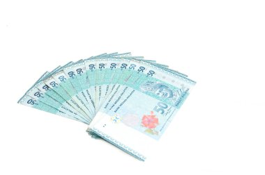 Malezya Para Birimi (MYR): Yüzük Malezya banknotu yığını. Masaya dağılmış yüzlerce halka halkalı Malezya var..