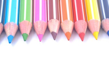Sıraya dizilmiş çeşitli renkli tahta kalemler.