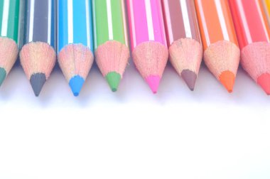 Sıraya dizilmiş çeşitli renkli tahta kalemler.