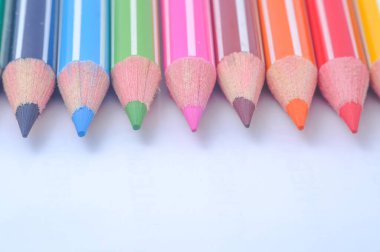 Sıraya dizilmiş çeşitli renkli tahta kalemler.