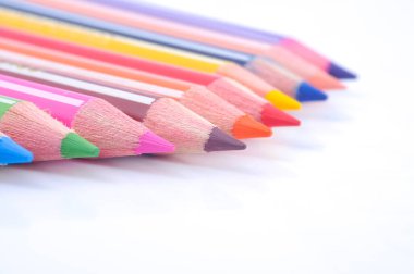 Sıraya dizilmiş çeşitli renkli tahta kalemler.