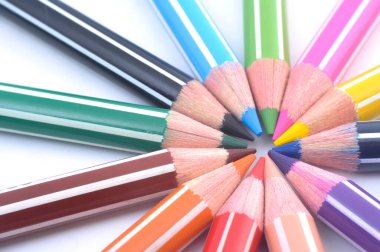 Sıraya dizilmiş çeşitli renkli tahta kalemler.