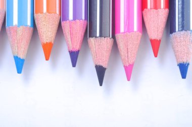 Sıraya dizilmiş çeşitli renkli tahta kalemler.