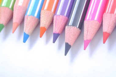 Sıraya dizilmiş çeşitli renkli tahta kalemler.