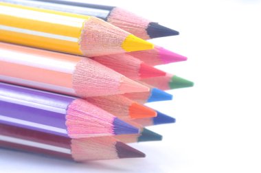 Sıraya dizilmiş çeşitli renkli tahta kalemler.