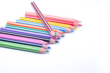 Sıraya dizilmiş çeşitli renkli tahta kalemler.