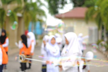  Kabarcık arka planında oynayan Bokeh ışığı ve bulanık çocuklar