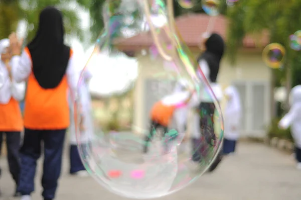 Размытое Изображение Детей Играющих Гигантский Пузырь — стоковое фото