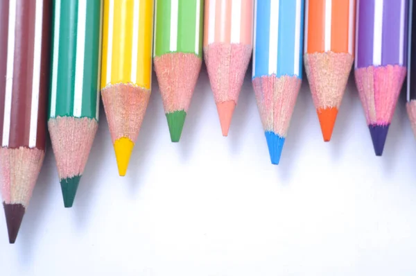 Various colored wooden pencil crayons placed in a row