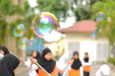  Kabarcık arka planında oynayan Bokeh ışığı ve bulanık çocuklar