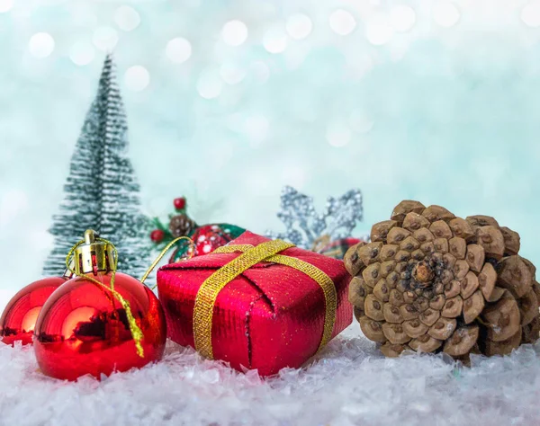 Noel süsleri, Noel hediyesi kutuları, mini çam ağaçlı çam kozalakları ve karların arkasında fotokopi alanı olan kar taneleri.