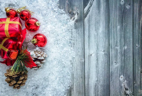 Noel süsleri ve çam kozalakları Noel 'in önünde tahta yüzeyde karla kaplı kutular, fotokopi alanı, üst manzara