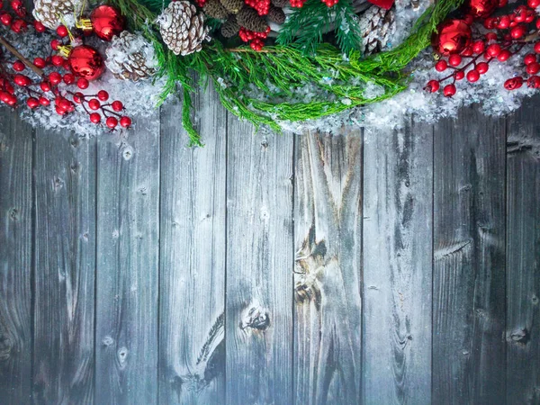 Kızılcık dalları, çam kozalakları ve dallar, karlı ahşap bir yüzey üzerinde noel süsleri fotokopi alanı, üst görünüm