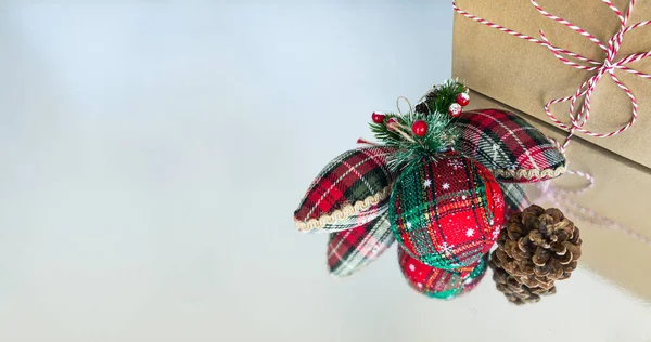 Noel süsleri ve noel hediyesi kutusunun önünde bir çam kozalağı fotokopi alanı ve ön görünümü olan yansıtıcı bir yüzey.