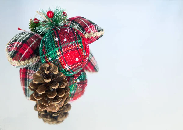 Noel süsleri ve yansıtıcı yüzeyde bir çam kozalağı fotokopi alanı, ön görüş, yakın çekim