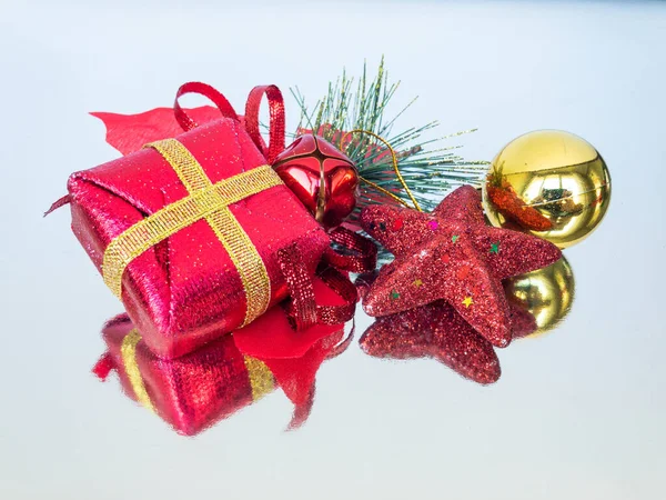 Noel süsleri ve yansıtıcı yüzeyde bir hediye kutusu, ön manzara, kapat