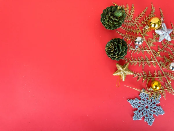 Noel süsleri, kırmızı izole bir yüzey üzerinde dallı çam kozalakları kopya alanı, üst görünüm