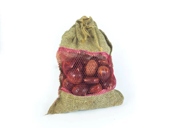 Çuval içinde bir yığın taze kestane. Fotokopi alanı olan beyaz izole bir arka plan. Noel için çiğ kestane. İçini gör.