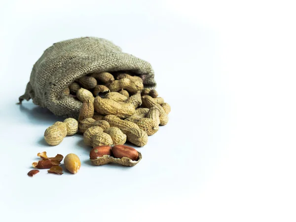 Çuval içinde fıstık yığını, izole edilmiş beyaz bir arka plan ve fotokopi alanı. Ön görünüm.