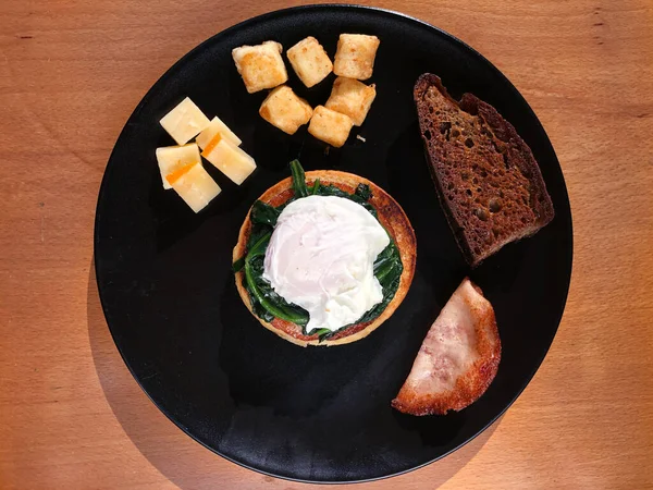 Kavrulmuş yumurta ve ıspanak, kızarmış İngiliz keki, kızarmış ekşi ekmek, sote halloumi, gouda, yanında da füme hindi salamı.