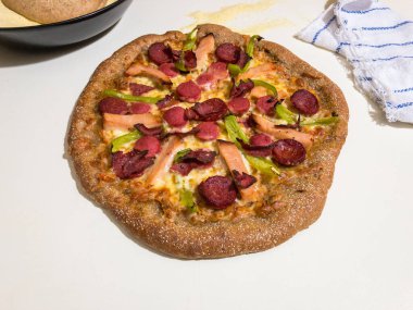 Ev yapımı tam buğday pizzası. Arkasında da pizza hamuru ve irmik.