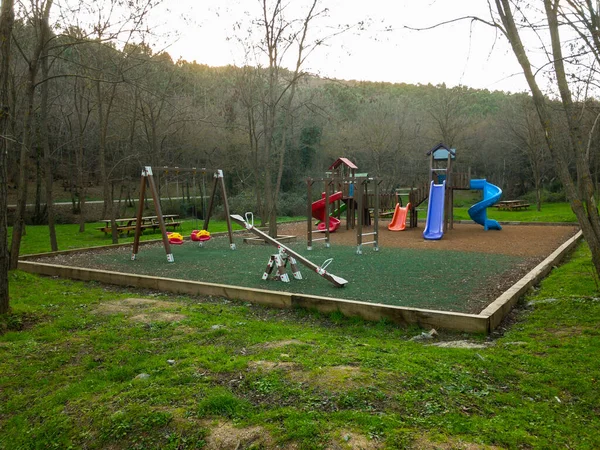 Etrafı ağaçlarla çevrili salgın yüzünden boş çocuk parkı