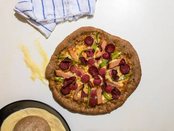 Yanında pizza hamuru ve irmikli ev yapımı tam buğday pizzası.