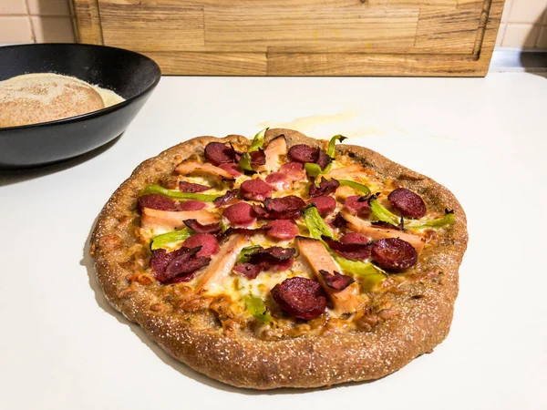 Ev yapımı tam buğday pizzası. Arkasında da pizza hamuru ve irmik.