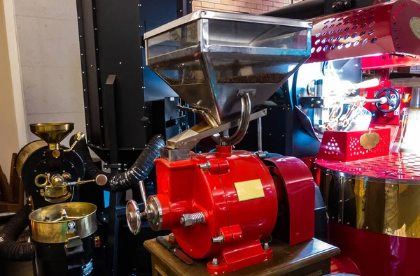 Arka planda kızartma makinesi olan kahve öğütücüsü.