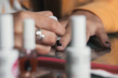 Kız tırnaklarını siyaha boyuyor.