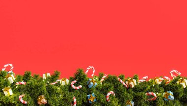 Kırmızı arka plan, altında hediyeler ve şekerlerle süslenmiş Noel çelengi. 3d oluşturma