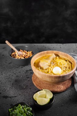 Tipik Peru yemeği tavuk çorbası olarak bilinir, limon ve soğanlı ahşap bir kasede..