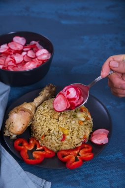 Tavuklu tipik Peru pilavı, mavi arka planda ve tamamlayıcı pancar salatası olarak sergileniyor..