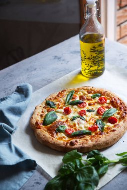 Dört çeşit peynirli ev yapımı pizza, vişneli domates ve fesleğen..