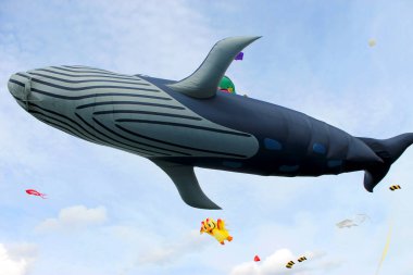 Birçok küçük uçan uçurtmalar ve büyük bir uçan balina şekilli uçurtma 
