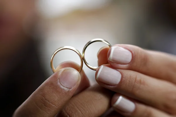 Mãos segurando anéis de casamento — Fotografia de Stock