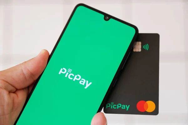 Minas Gerais, Brezilya - 25 Ocak 2021: PicPay ve Mastercard markalı cep telefonu ekran ve kredi kartı. Dijital ödeme sistemi.