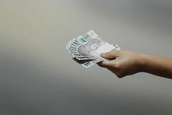 Hands holding Brazilian real notes, Brazil BRL banknote, Brazilian currency, economy and business.