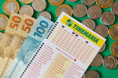 Minas Gerais, Brezilya - 22 Şubat 2021: nakit para, bozuk para ve piyango bileti Caixa Timemania