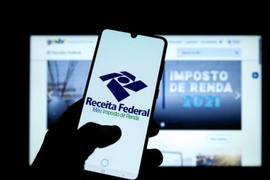 Minas Gerais, Brezilya - 21 Mart 2021: Müşteri Brezilya federal gelirinin gelir vergisi uygulamasını cep telefonunda kullandı
