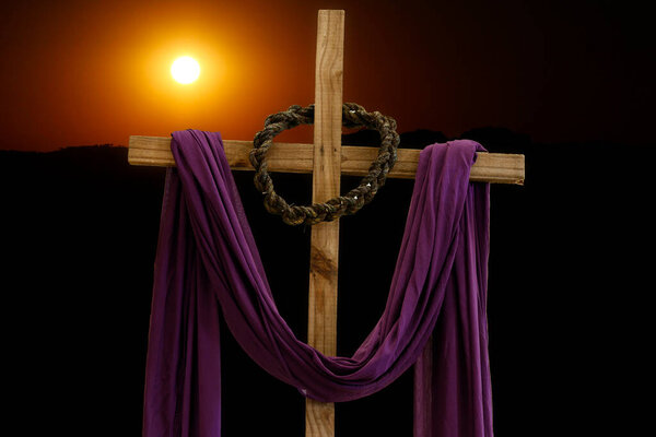 wooden cross with crown of thorns and purple fabric, catholic symbols, time of lent