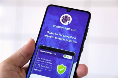 Minas Gerais, Brezilya - 19 Nisan 2021: Coronavirus SUS do Brasil uygulaması ile cep telefonu ekranı