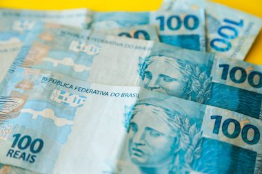 Sarı yüzeye yığılmış Brezilya 'dan gelen para. Birkaç yüz gerçek banknot.