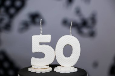 50. yaş günü pastasında beyaz mumlar yaktı. Kilometre taşı kutlamaları, altın yıldönümü partileri ve sofistike dekorlar için mükemmel. Yüksek çözünürlüklü, nötr sıralı